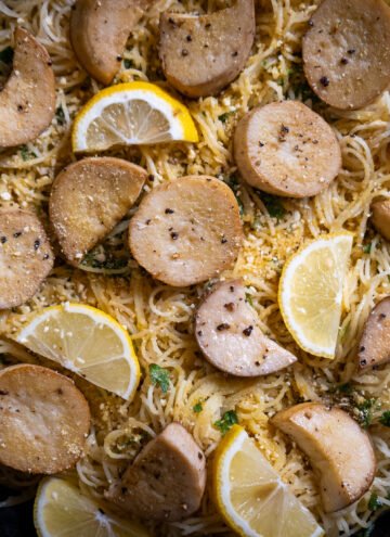 Close up of angel hair pasta dish with vegan scallops in a cast iron pan.