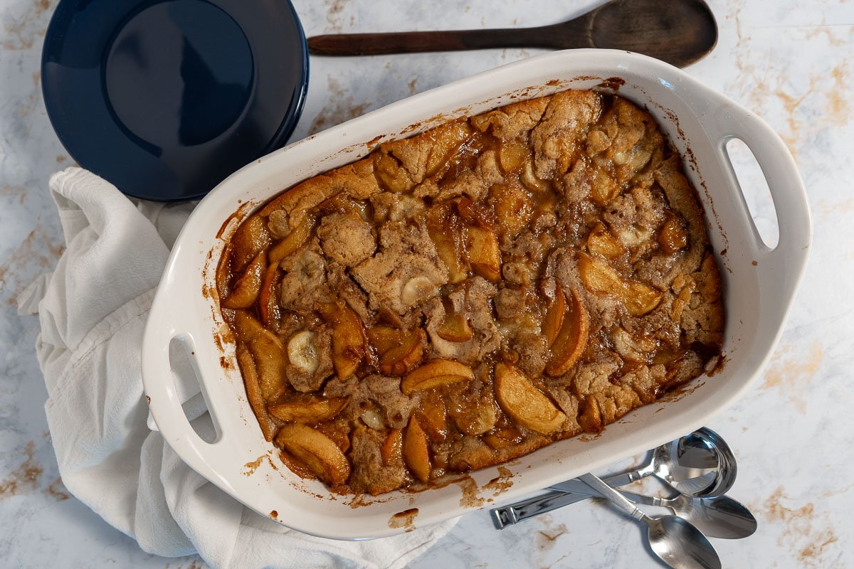 Looking straight down on a vegan peach cobbler in a serving dish.