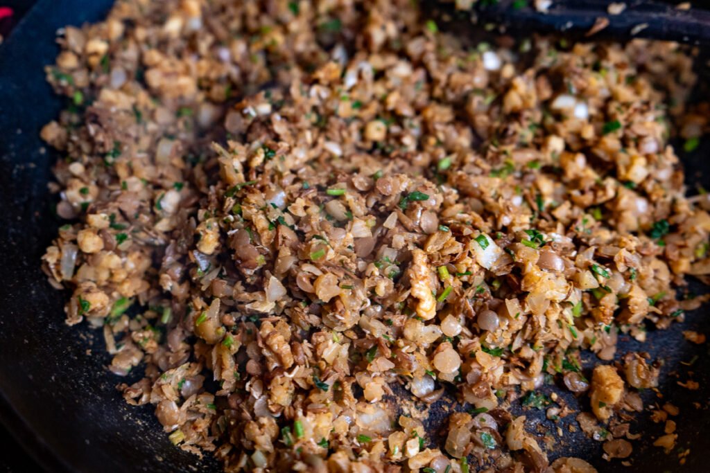 Walnuts, lentils, onion, garlic, parsley, and spices cooked on a cast iron pan.