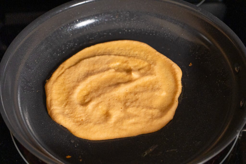 A lentil wrap being cooked in a pan.