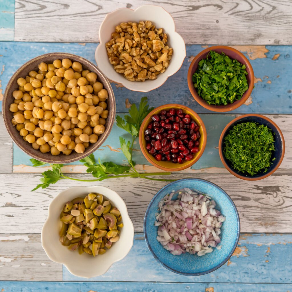 All of the ingredients for the chickpea salad in small bowls