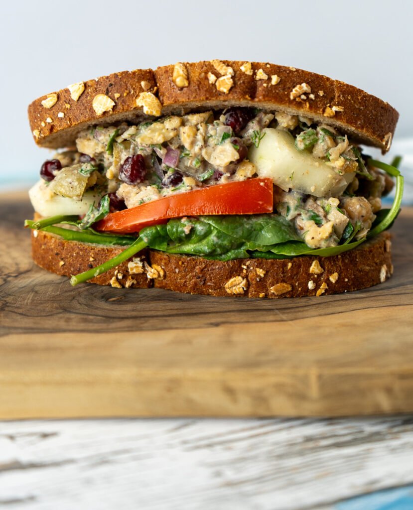 A side view of the Za'atar Chickpea Sandwich on a wooden board.