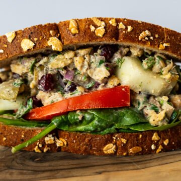 A side view of the Za'atar Chickpea Sandwich on a wooden board.