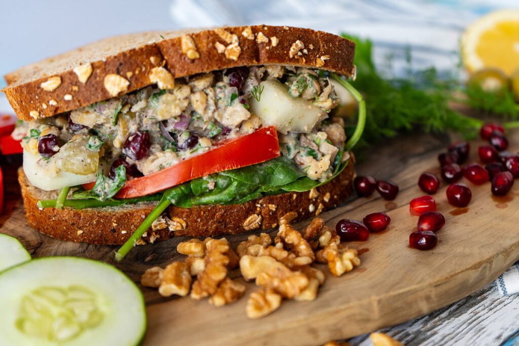 A side view of the Za'atar Chickpea Sandwich on a wooden board.