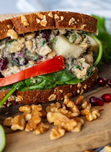 A side view of the Za'atar Chickpea Sandwich on a wooden board.