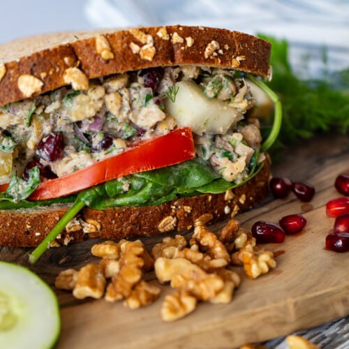 A side view of the Za'atar Chickpea Sandwich on a wooden board.