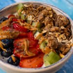 A bowl of yogurt with the fruit and granola.