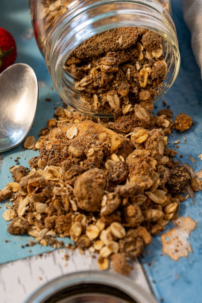 High Protein Vegan Granola spilling out of a mason jar.