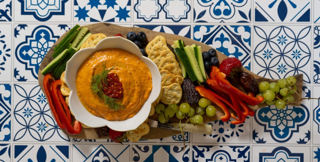 Spicy roasted red pepper dip on a charcuterie board.