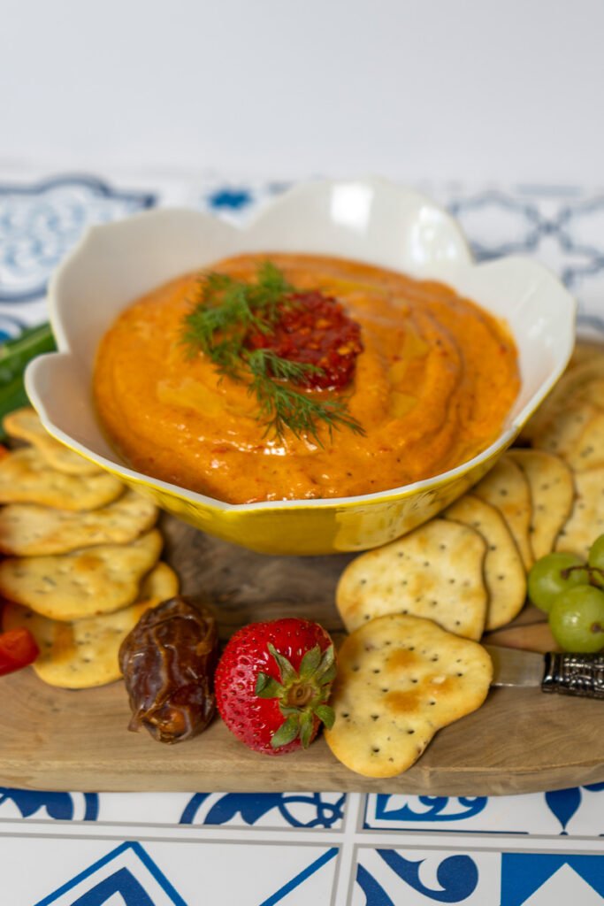 Spicy roasted red pepper dip on a charcuterie board.