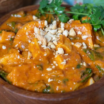 A bowl of west African tofu peanut stew in a wooden bowl.