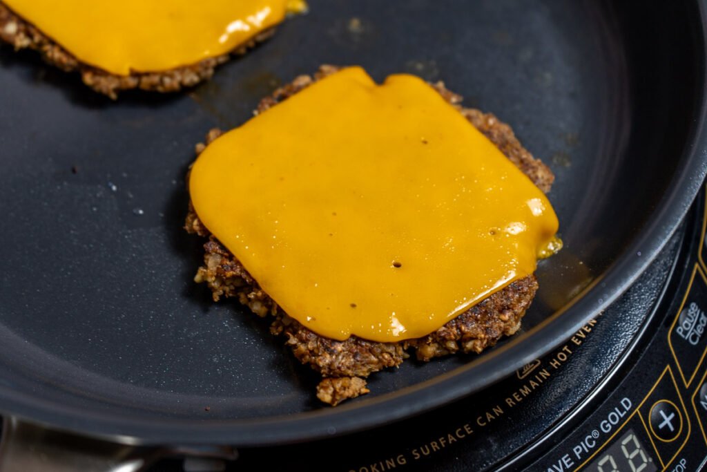 Walnut mushroom smash burger on a pan with cheese on top