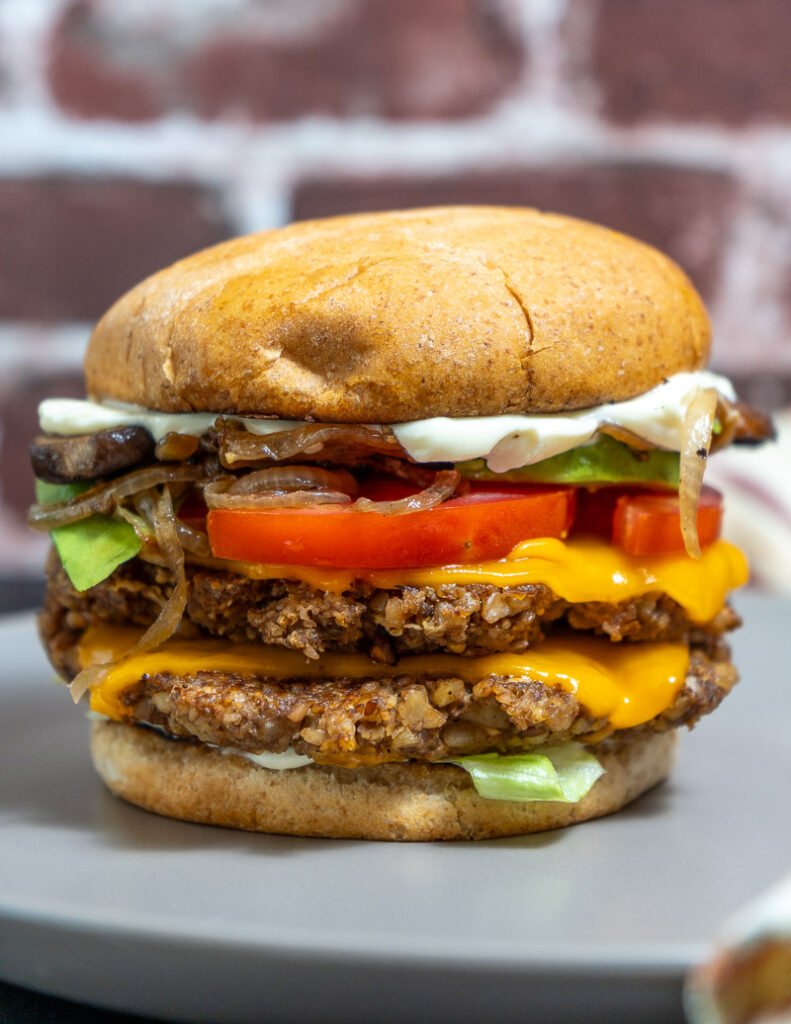 Side view of a walnut mushroom smash burger on a plate