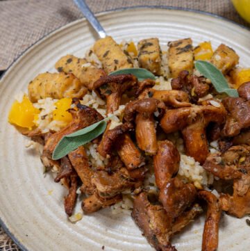 Butternut squash risotto with sage tempeh and mushrooms on a plate with a fork.