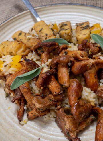 Butternut squash risotto with sage tempeh and mushrooms on a plate with a fork.